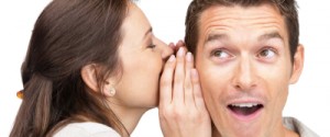 Young woman telling a secret to a man